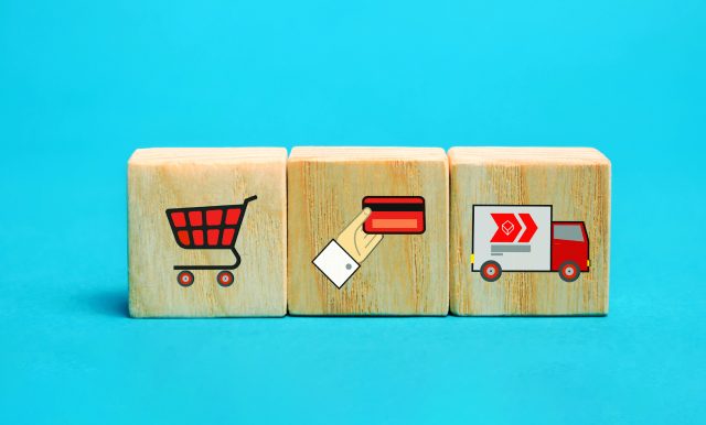 Shopping cart, credit card, and truck icons on wooden blocks