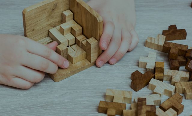 person assembling wooden cube